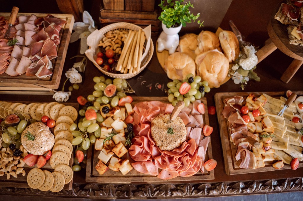 An abundant charcuterie and cheese spread on rustic wooden boards